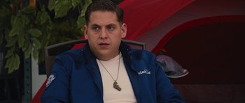 Movie still from “The Watch” (2012), directed by Akiva Schaffer – A person sitting in a chair wearing a blue jacket; Close Up shot, Over the shoulder angle