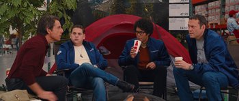 Movie still from “The Watch” (2012), directed by Akiva Schaffer – Two men sitting in front of a red tent drinking coke; Medium shot, Over the shoulder angle