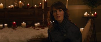 Movie still from “The Watch” (2012), directed by Akiva Schaffer – A woman sitting on a chair in front of candles; Close Up shot, Over the shoulder angle