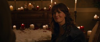 Movie still from “The Watch” (2012), directed by Akiva Schaffer – A woman sitting in front of candles in a room; Close Up shot, Over the shoulder angle