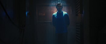 Movie still from “The Watch” (2012), directed by Akiva Schaffer – A man standing in a dark room with a light shining on him; Medium shot, Low angle
