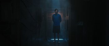 Movie still from “The Watch” (2012), directed by Akiva Schaffer – A man standing in a dark room in front of a door; Medium shot, Low angle