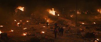 Movie still from “The Watch” (2012), directed by Akiva Schaffer – A group of people standing around a burning building at night; Extreme Wide shot, High angle