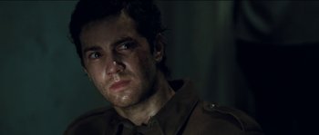 Movie still from “The Way Back” (2010), directed by Peter Weir – A person wearing a military uniform; Close Up shot, Over the shoulder angle