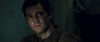 Movie still from “The Way Back” (2010), directed by Peter Weir – A person wearing a military uniform; Close Up shot, Over the shoulder angle