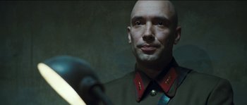 Movie still from “The Way Back” (2010), directed by Peter Weir – A man in a military uniform looking into a mirror; Close Up shot, Low angle