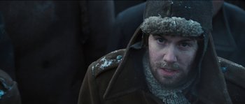 Movie still from “The Way Back” (2010), directed by Peter Weir – A person wearing a coat and a hat; Close Up shot, Low angle