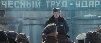 Movie still from “The Way Back” (2010), directed by Peter Weir – An older man wearing a hat and a jacket; Medium shot, Over the shoulder angle