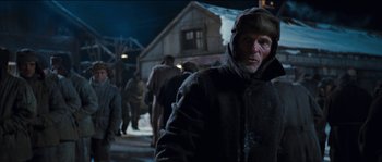 Movie still from “The Way Back” (2010), directed by Peter Weir – A man in a hooded jacket standing in the snow; Medium shot, Low angle