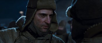 Movie still from “The Way Back” (2010), directed by Peter Weir – A person wearing a jacket and a hat; Close Up shot, Low angle