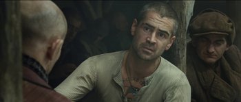 Movie still from “The Way Back” (2010), directed by Peter Weir – A man that is sitting in front of a wall; Close Up shot, Over the shoulder angle
