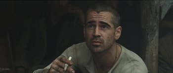 Movie still from “The Way Back” (2010), directed by Peter Weir – A person holding a cigarette in his hand; Close Up shot, Low angle