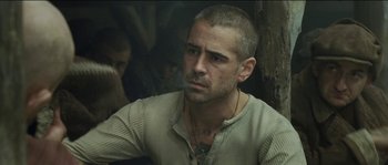Movie still from “The Way Back” (2010), directed by Peter Weir – A man that is sitting in front of a wall; Close Up shot, Over the shoulder angle
