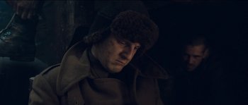 Movie still from “The Way Back” (2010), directed by Peter Weir – A man wearing a brown coat and a fur hat; Close Up shot, Low angle