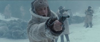 Movie still from “The Way Back” (2010), directed by Peter Weir – A man holding a gun while standing in the snow; Close Up shot, Low angle