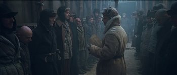 Movie still from “The Way Back” (2010), directed by Peter Weir – A group of men standing in front of each other in a forest; Wide shot, Low angle