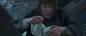 Movie still from “The Way Back” (2010), directed by Peter Weir – An old man is holding a piece of cloth; Close Up shot, Low angle