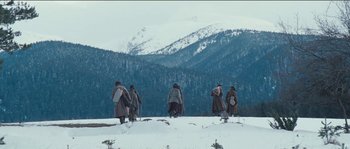 Movie still from “The Way Back” (2010), directed by Peter Weir – A group of people standing on top of a snow covered slope; Extreme Wide shot, Low angle