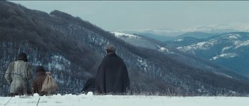 Movie still from “The Way Back” (2010), directed by Peter Weir – A man sitting on top of a snow covered slope; Extreme Wide shot, Low angle