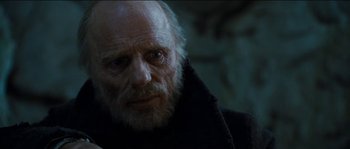 Movie still from “The Way Back” (2010), directed by Peter Weir – An old man with a beard is looking at the camera; Close Up shot, Low angle