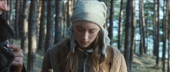 Movie still from “The Way Back” (2010), directed by Peter Weir – A young woman in a white hat is standing in the woods; Close Up shot, Over the shoulder angle