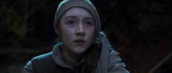 Movie still from “The Way Back” (2010), directed by Peter Weir – A young woman with a hat and scarf on; Close Up shot, Low angle