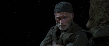Movie still from “The Way Back” (2010), directed by Peter Weir – An old man wearing a hat and a scarf; Close Up shot, Over the shoulder angle