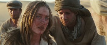 Movie still from “The Way Back” (2010), directed by Peter Weir – A man and a woman are standing next to each other; Close Up shot, Over the shoulder angle