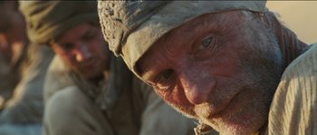 Movie still from “The Way Back” (2010), directed by Peter Weir – A person with a hat on; Extreme Close Up shot, Low angle