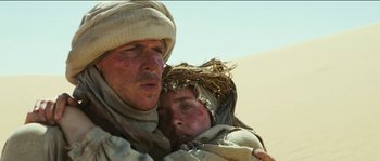 Movie still from “The Way Back” (2010), directed by Peter Weir – A man and a child in the desert; Close Up shot, Low angle