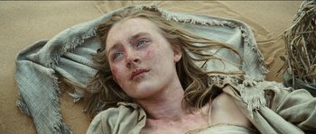 Movie still from “The Way Back” (2010), directed by Peter Weir – A woman laying on the ground with a blanket around her head; Close Up shot, Overhead angle