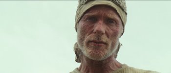 Movie still from “The Way Back” (2010), directed by Peter Weir – An old man with a beard and a hat on; Close Up shot, Low angle