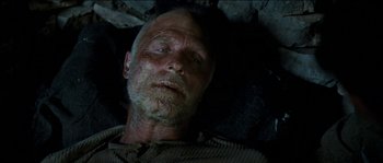 Movie still from “The Way Back” (2010), directed by Peter Weir – An old man laying on the ground in the dark; Close Up shot, Overhead angle