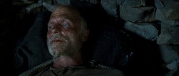 Movie still from “The Way Back” (2010), directed by Peter Weir – An old man laying on the ground in the dark; Close Up shot, Overhead angle