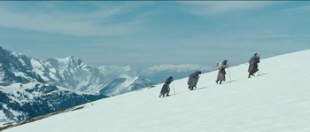 Movie still from “The Way Back” (2010), directed by Peter Weir – A group of people walking up a snow covered slope; Extreme Wide shot, High angle