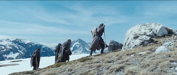 Movie still from “The Way Back” (2010), directed by Peter Weir – Two men are walking up a hill in the mountains; Wide shot, Low angle