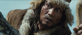 Movie still from “The Way Back” (2010), directed by Peter Weir – A person wearing a coat and hat; Close Up shot, Low angle