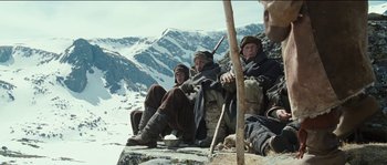 Movie still from “The Way Back” (2010), directed by Peter Weir – A group of men sitting on top of a mountain; Wide shot, Low angle