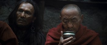 Movie still from “The Way Back” (2010), directed by Peter Weir – An older man is holding a cup in his hands; Close Up shot, Low angle