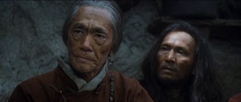 Movie still from “The Way Back” (2010), directed by Peter Weir – A man in a red shirt and a man in a black and brown shirt; Close Up shot, Low angle