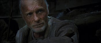 Movie still from “The Way Back” (2010), directed by Peter Weir – An old man with a beard is looking at the camera; Close Up shot, Low angle