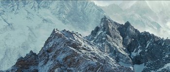 Movie still from “The Way Back” (2010), directed by Peter Weir – A mountain range with snow on the top of it's slopes; Extreme Wide shot, Low angle