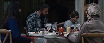 Movie still from “The Way Back” (2020), directed by Gavin O'Connor – A group of people sitting at a dinner table; Medium shot, Over the shoulder angle