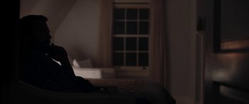 Movie still from “The Way Back” (2020), directed by Gavin O'Connor – A person sitting on a bed in front of an open window; Medium shot, Over the shoulder angle
