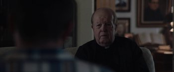 Movie still from “The Way Back” (2020), directed by Gavin O'Connor – An older man sitting in front of another man; Close Up shot, Over the shoulder angle