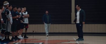 Movie still from “The Way Back” (2020), directed by Gavin O'Connor – A man standing on a basketball court in front of a wall; Wide shot, Low angle