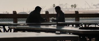 Movie still from “The Way Back” (2020), directed by Gavin O'Connor – Two men are sitting at a table and drinking coffee; Wide shot, Over the shoulder angle