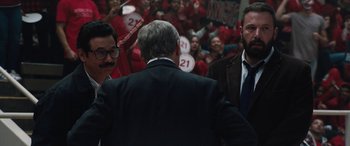 Movie still from “The Way Back” (2020), directed by Gavin O'Connor – A group of men standing next to each other in a room; Medium shot, Over the shoulder angle