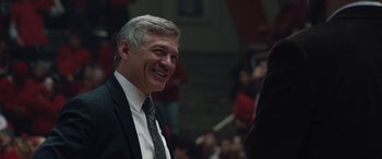 Movie still from “The Way Back” (2020), directed by Gavin O'Connor – A person wearing a suit and tie; Close Up shot, Over the shoulder angle