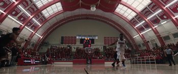 Movie still from “The Way Back” (2020), directed by Gavin O'Connor – A group of men playing a game of basketball in a gym; Extreme Wide shot, High angle